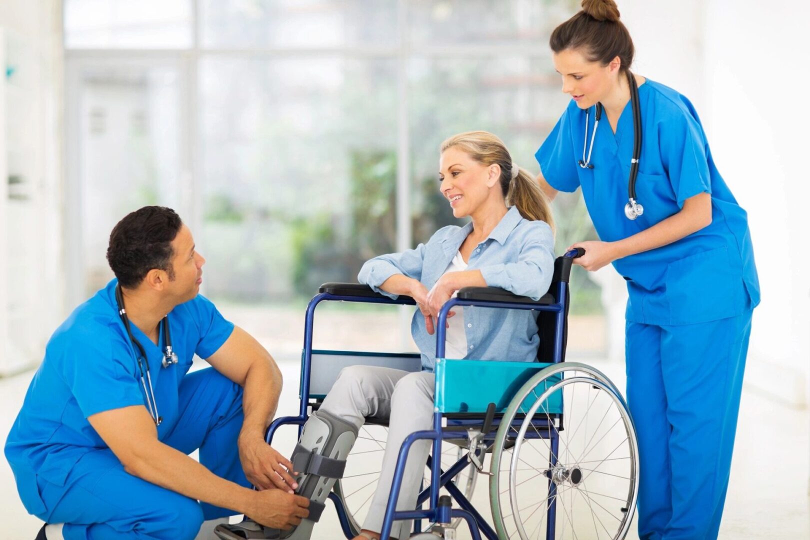 A group of doctors and nurses standing around a patient in a wheelchair.